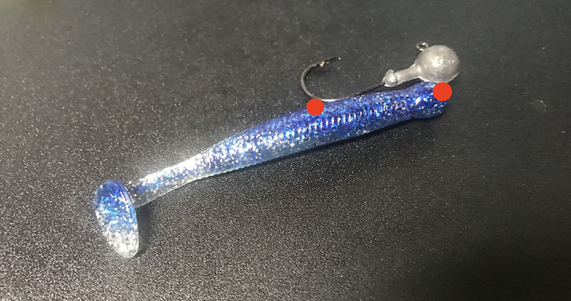 ジグヘッドの針をワームに刺す細かい位置。赤い丸が付いている箇所に針を刺すようにする。