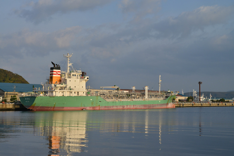 室蘭港の夕方の風景。大きな緑色の貨物船が停泊している。
