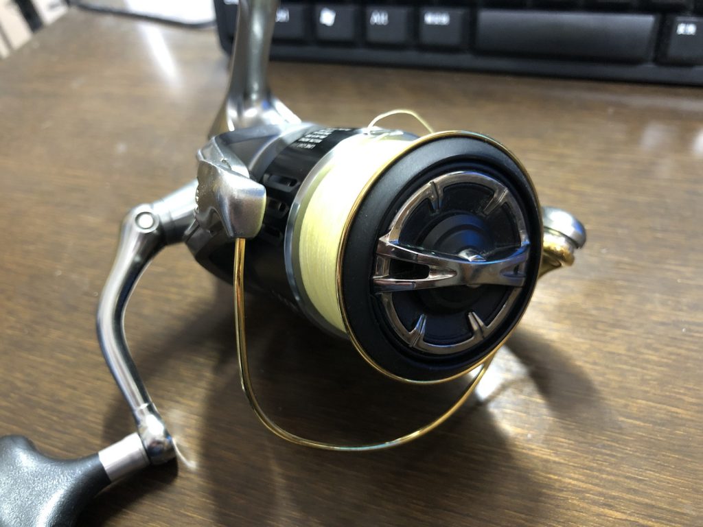 テーブルの上に置かれたスピニングリールのドラグの部分をアップにして撮影