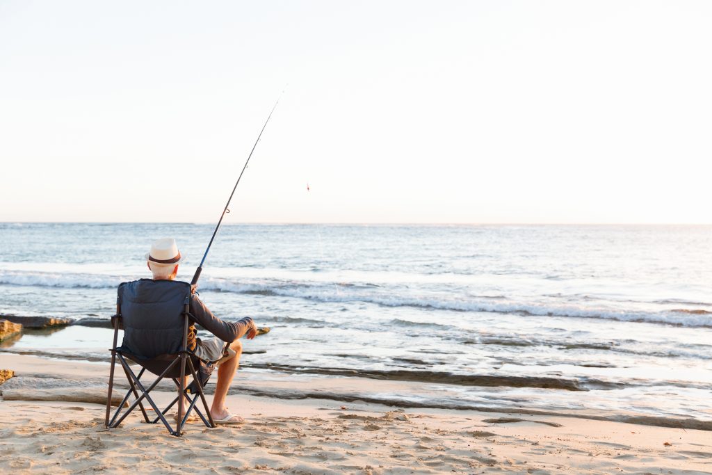 年配のおじさんがサーフで暇そうに釣りをしている